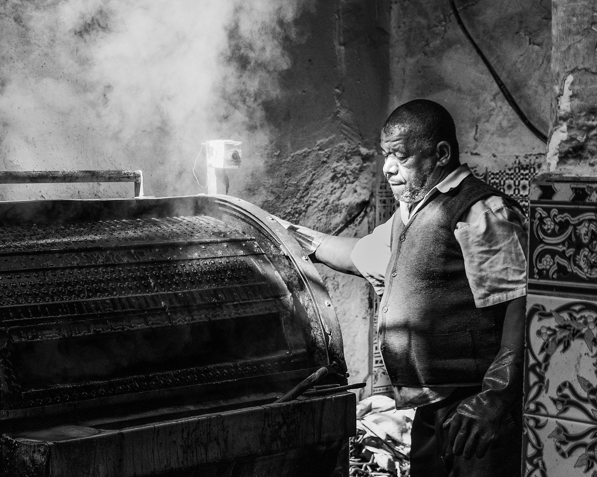 The Craft of Historical Leather Tanning: A Tanner Working with a Steaming Antique Drum About 60 Years Ago. Historical leather tanning: A tanner operates a large, steaming antique leather drum about 60 years ago.